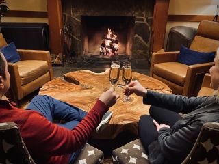 couple sitting by fire with champagne